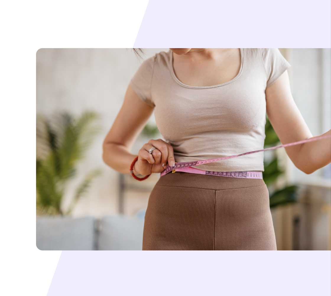 A woman using a measuring tape to take her body measurements.